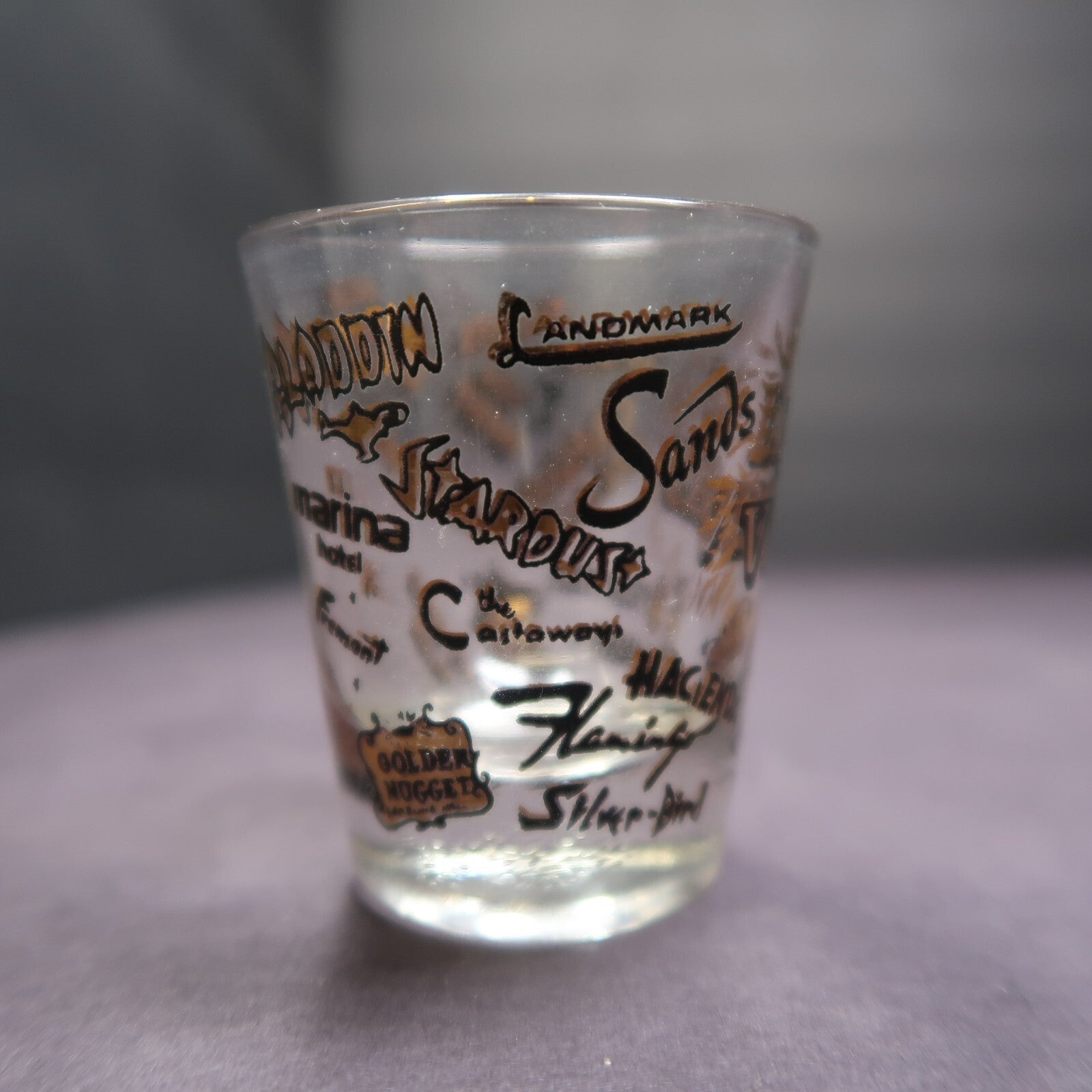 Vintage Las Vegas Souvenir Shot Glass Casino Names Black and Gold on Clear